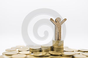 Business, Finance, Money Saving and Success Concept. Close up of wooden man figure  on top of stack of gold coins on white