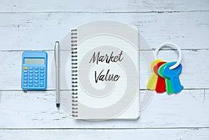 Business,finance and property concept. Top view of calculator,pen,keys and notebook written with Market Value.