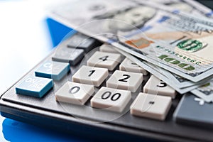 Business and financial background with dollars and calculator. Bookkeeping background.