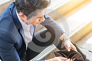 business financial concept : sad poor problem businessman holding no money open wallet