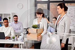 Colleague seeing off fired employee leaving office photo