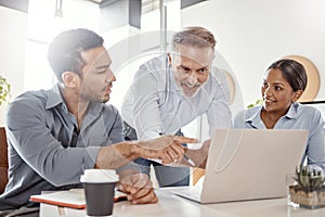 Business gets better with brilliant minds like theirs. a group of businesspeople using a laptop in a modern office.