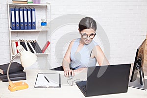Business girl in glasses sits in an Office at a computer folder paper