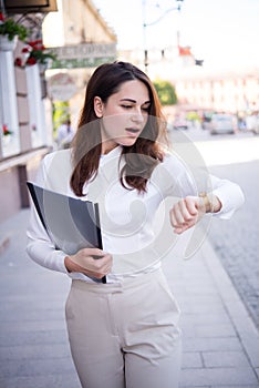 Business girl in a hurry looking at her watch