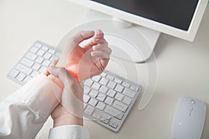 Business girl with pain on the wrist. Work in computer. Office syndrome