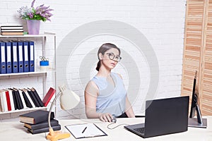 Business girl sits at a computer in the Office paper folders