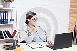 Business girl sits at a computer in the Office paper folders