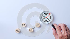 Business goal concept. Hand holding magnifying glass focus on target icon. Step in planning development for success, marketing