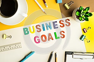 Business goals word on desk office background with supplies.