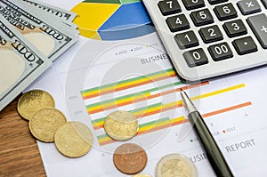 Business graph, coins with dollars and a calculator on the table. Revenue Analysis Concept and Business Development Strategy