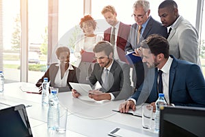 Business group carefully studying tablet