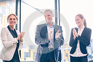 Business group clapping and smiling