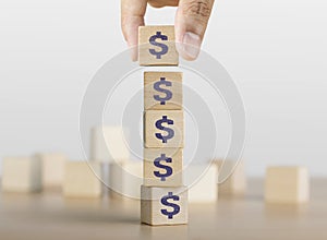 Business growth, increase profit, increase income or saving concept. Hand arranging wooden blocks with the US Dollar symbol