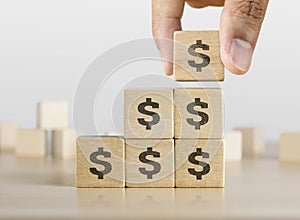 Business growth, increase profit, increase income or saving concept. Wooden blocks with the US Dollar symbol arranged in stair