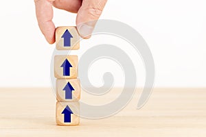 Business growth process concept. Hand holding a wooden block with Arrow icon