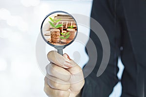 Business growth ,success ,investment concept background with woman hand holding magnifying glass with coin