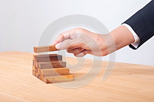 business hand arranging wood block stacking as step stair. Ladder career path concept for business growth success process