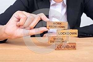 Business hand building corona virus covid-19 concept with wooden blocks on wood, covid-19, Social distancing, lockdown, work from