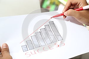 Business hand drawing business success profit graph idea in piece of paper