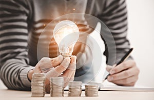 Business hand holding light bulb and working with computer on the desk, Creativity and innovation are keys to success.Concept of n