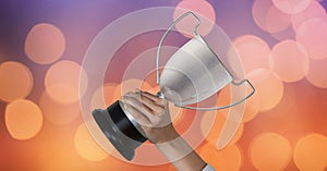 Business hand holding trophy against abstract background