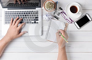 Business hand man using computer and writing on blank notebook