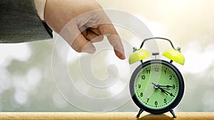 Business hand pointing an alarm clock