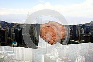 Business hand shake with abstract office buildings in background