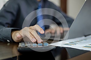 The business hand sits at their desks and calculates financial graphs showing the results of their investments planning the