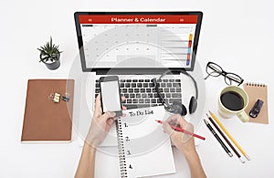 Business hand typing on a laptop keyboard with Calender Planner