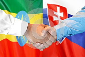Potřesení rukou na pozadí vlajky Etiopie a Slovenska
