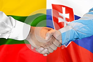 Handshake na pozadí vlajky Litvy a Slovenska. Koncepce podpory