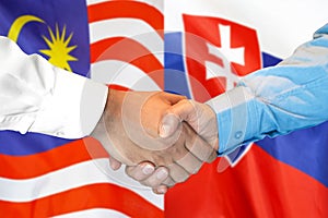 Handshake on Malaysia and Slovakia flag background