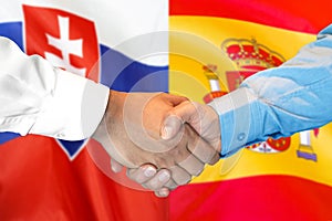 Potřesení rukou na pozadí vlajky Slovenska a Španělska
