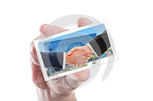 Business handshake concept on card hold by hand