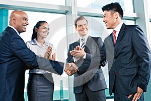 Business handshake in lofty office with city view