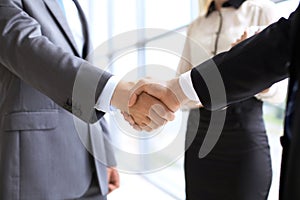 Business handshake at meeting or negotiation in the office. Partners are satisfied because signing contract or financial