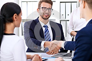 Business handshake at meeting or negotiation in the office. Partners are satisfied because signing contract or financial