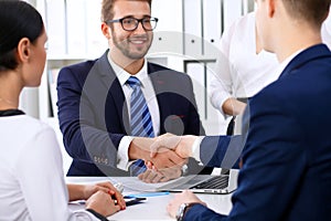 Business handshake at meeting or negotiation in the office. Partners are satisfied because signing contract or financial