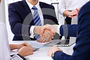 Business handshake at meeting or negotiation in the office. Partners are satisfied because signing contract or financial