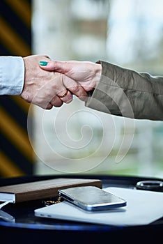 Business handshake men and women over laptop and phone. agreement, success and trust