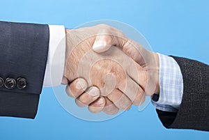 Business handshake over blue background