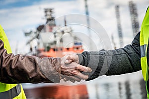 Business handshake in a shipyard. Shipbuilding industry