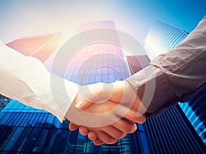 Business handshake, skyscrapers background. Deal, success, cooperation