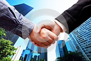 Business handshake, skyscrapers background. Deal, success, cooperation