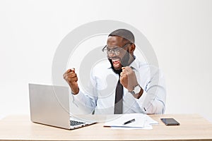 Business is his life. Cheerful young African man in formal wear and working on laptop