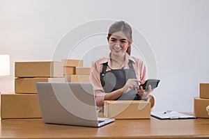 Business From Home Asian woman preparing package delivery box Shipping for shopping online. young start up small
