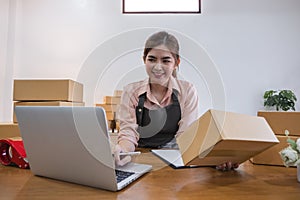 Business From Home Asian woman preparing package delivery box Shipping for shopping online. young start up small