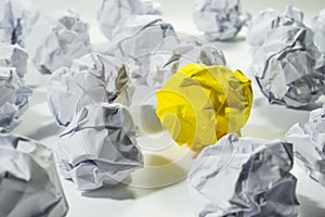 Ideas concept with yellow crumpled paper ball.