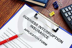 Business interruption insurance form and pen for signing.